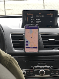 a person in a car with a cell phone on the dashboard