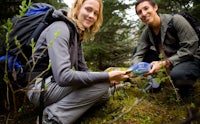 a man and woman hiking in the woods