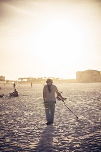 a person walking on the beach with a kite