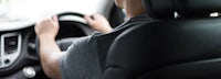 a man driving a car with his hands on the steering wheel